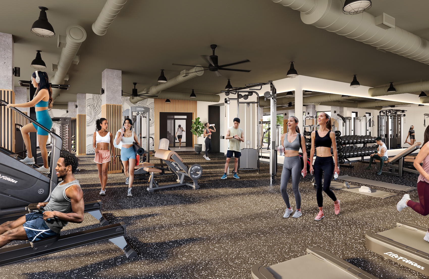 A modern gym in University of Maryland housing, with people working out on treadmills, stair climbers and weight machines. Some walk and chat while others exercise. The gym features bright lighting and a spacious layout.