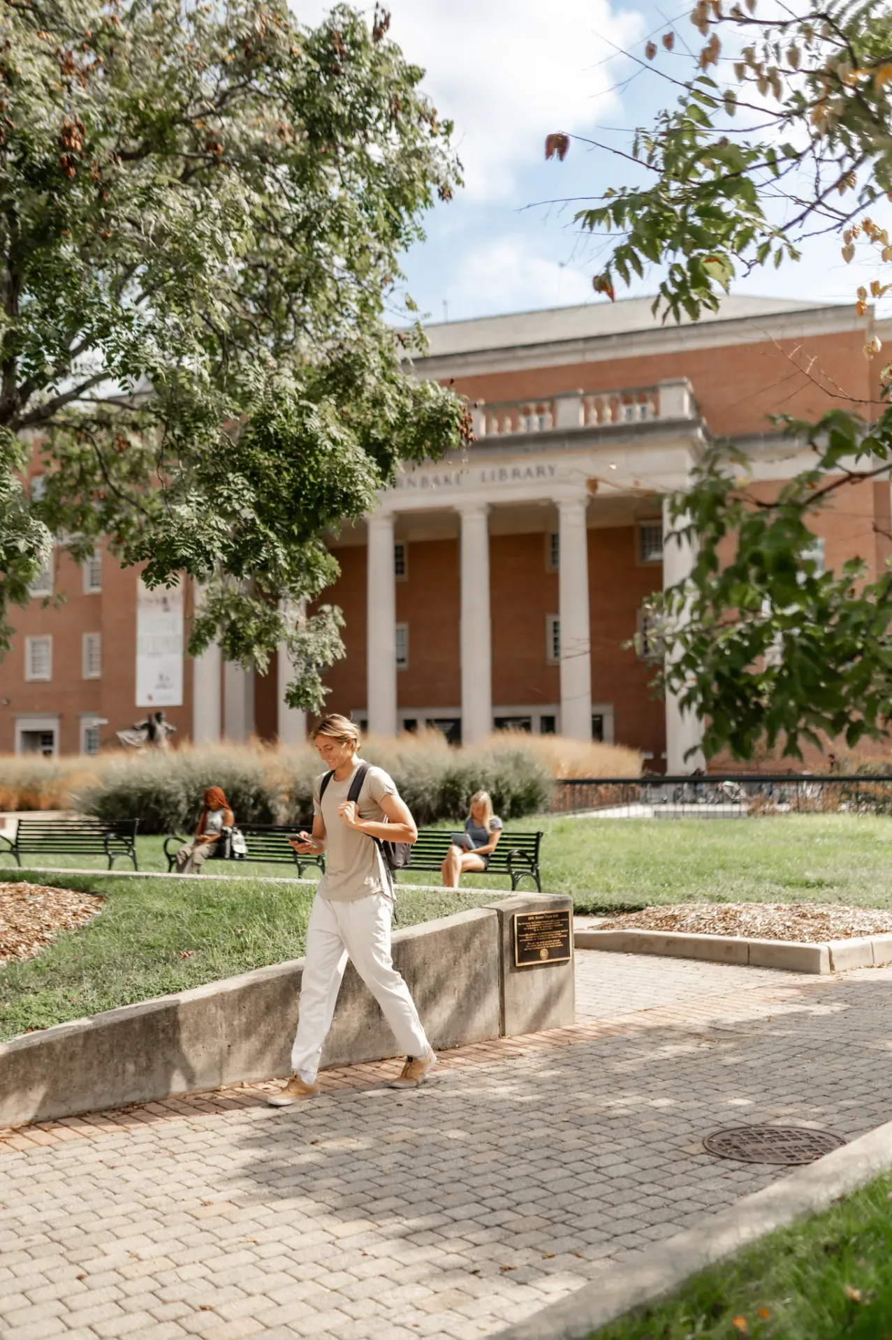 Student walking past a campus building at the University of Maryland
