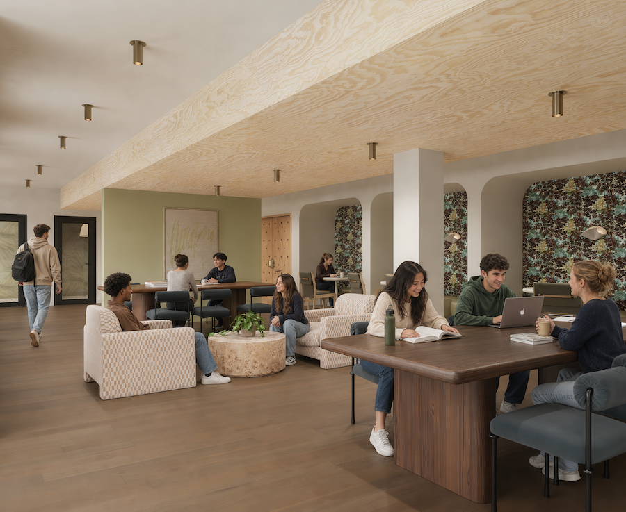 People are working and studying in a modern lounge at Rambler College Park South, with wood floors, patterned walls, and neutral furniture. Some sit at tables with laptops and notebooks, while others relax or walk through the room.