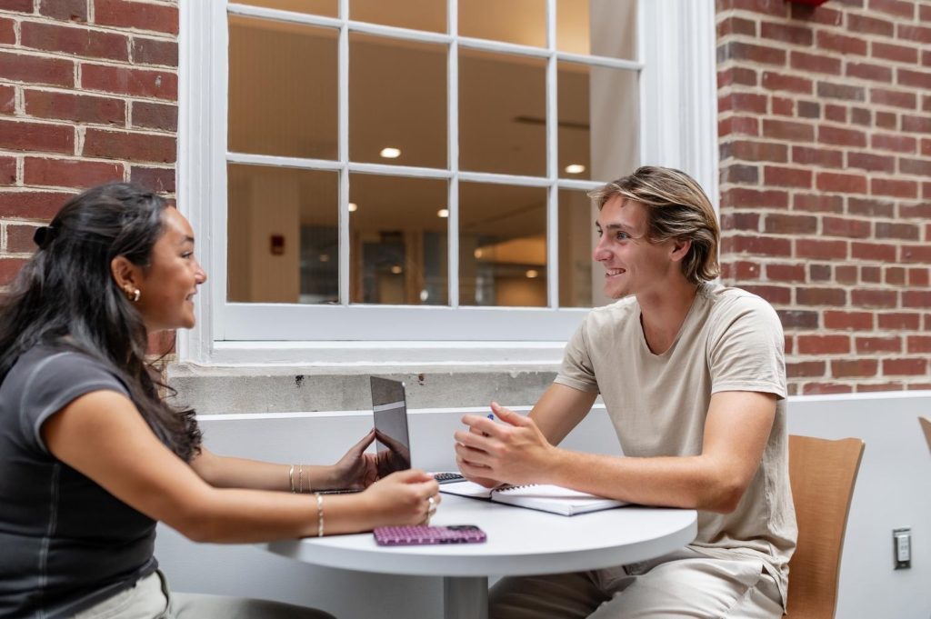 Two students talking to each other on UMD campus near Rambler College Park.