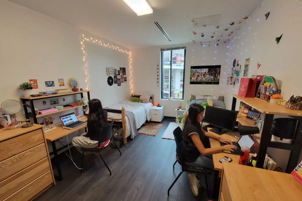 Well-decorated dorm room at UMD with two students studying at their desks.