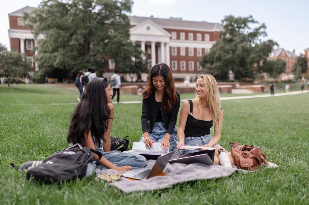 Three students studying on UMD campus near Rambler College Park.