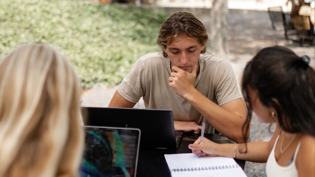 UMD students collaborate on an assignment on notebooks and laptops.