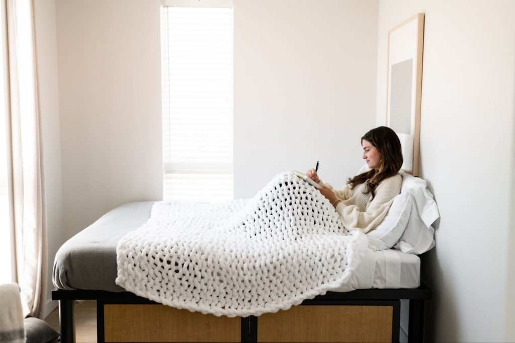 Student relaxing in their bedroom in an off-campus apartment in College Park.