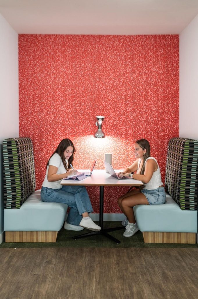 Two students hanging out in a common area at their apartment complex near UMD.