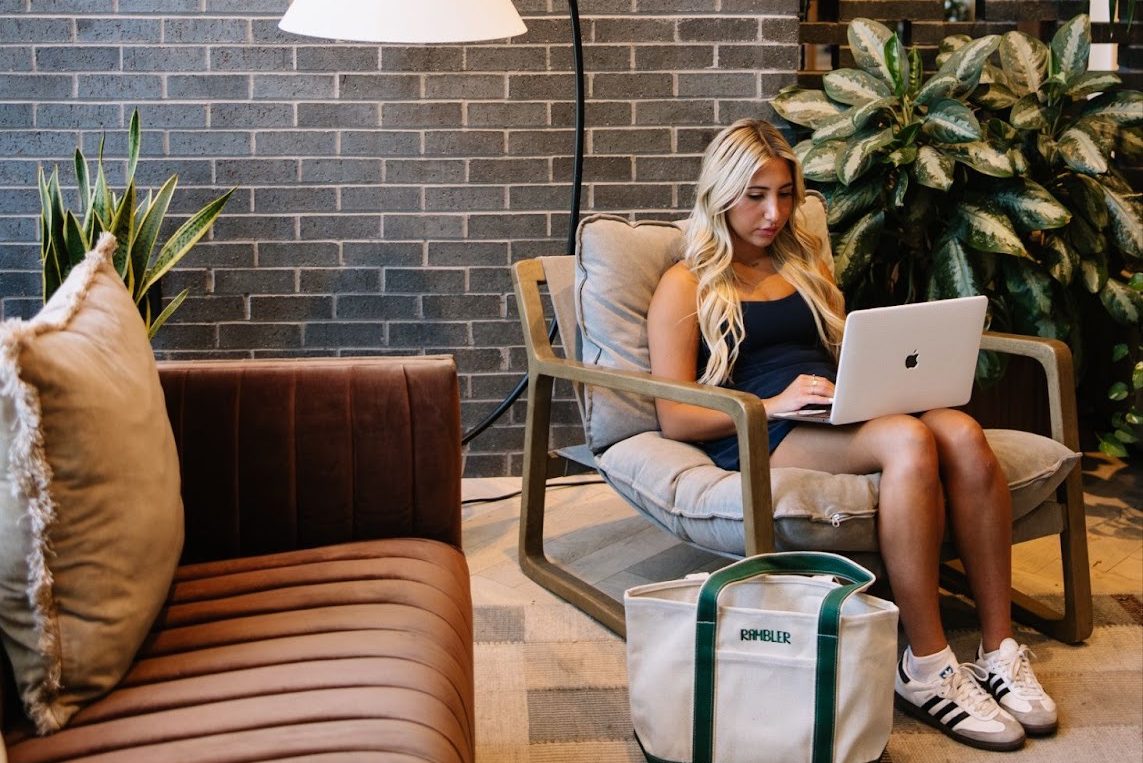 A UMD student works on their laptop in the Rambler College Park lobby.