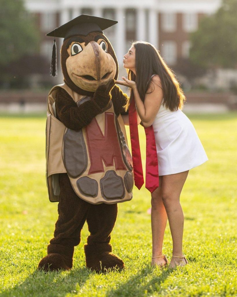 Student taking graduation photos with Testudo. 