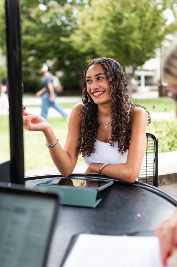 Student outside Robert H. Smith School of Business, studying with friends. 