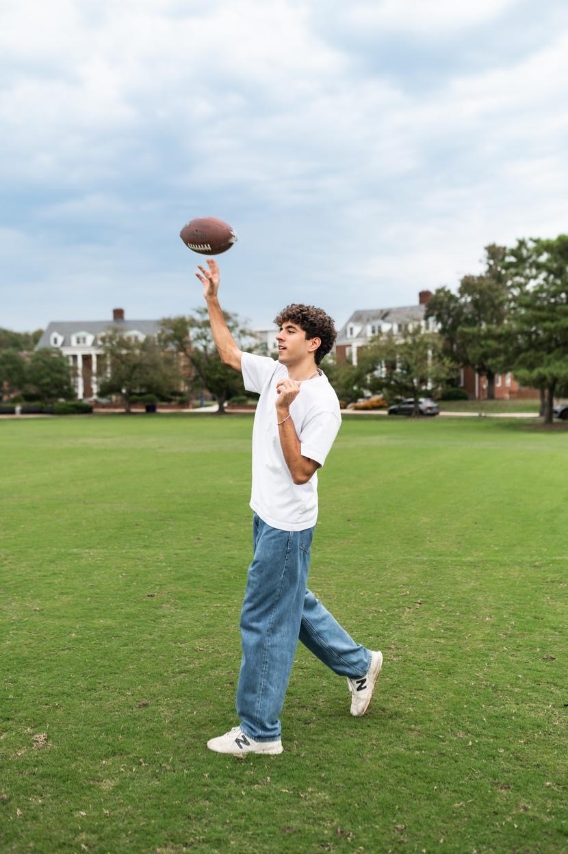 Student playing with a football outside near UMD campus. 