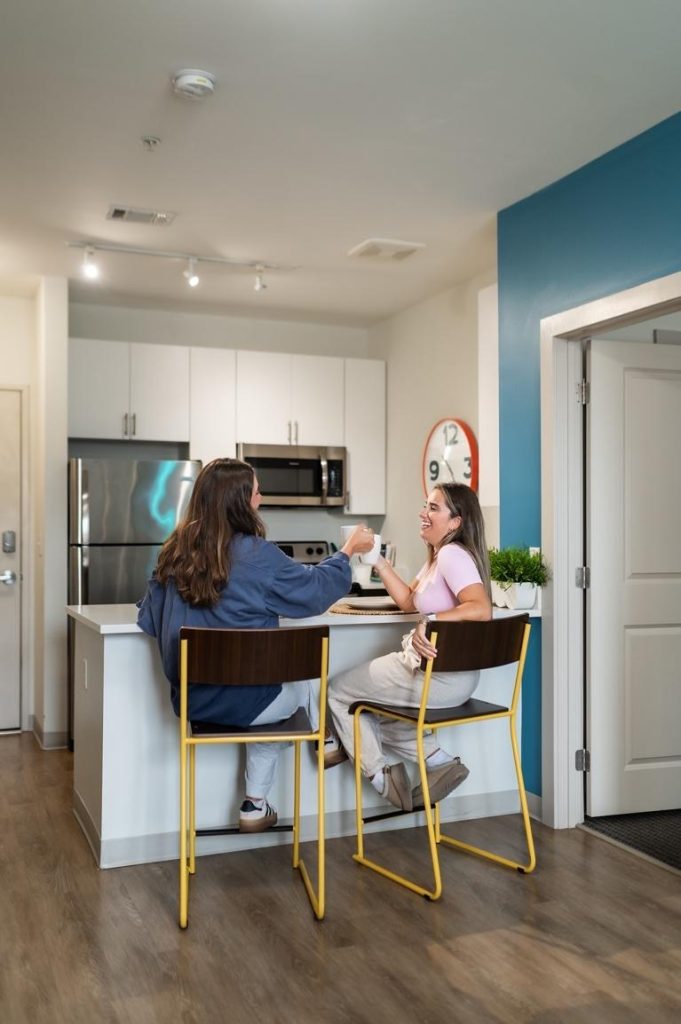 Students spending time in their kitchen in their off-campus apartment at UMD. 
