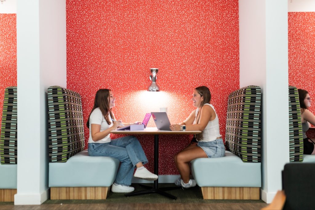 Study booth with patterned seating and a red speckled accent wall